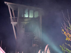 Four-story home with heavy damage from fire at night
