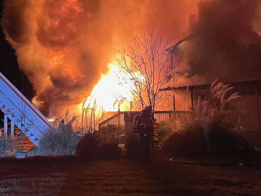 Large fire consuming a multi-story home at night