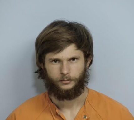 Mug shot of Josh Horak, 20, wearing an orange jump suit with brown hair and a bushy brown beard.