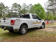 White animal control officer truck loaded down with wire fencing and fence posts