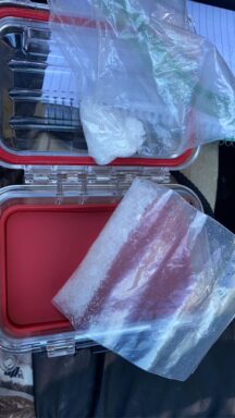 A red case revealing two clear plastic baggies with a white substance inside.