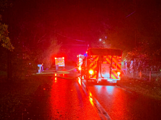 Fire engines with bright red lights parked in the road