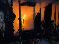 Orange flames from inside a damaged home