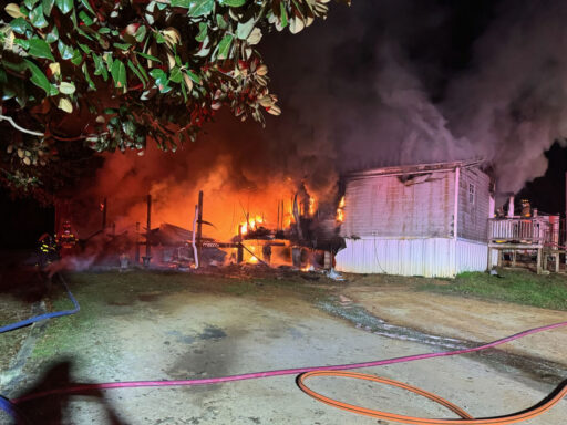 Double wide mobile home on fire at night