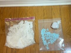 Methamphetamine crystallized in a plastic bag and a bag of blue pills.