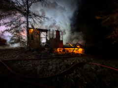 Heavy smoke coming from a burned down mobile home at night