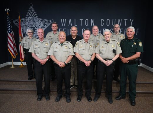 A group of Walton County Sheriff's Office Posse posing in front of a wall that reads, "Office of the Sheriff, Walton County"