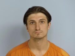 Mug shot of a while male with longer brown hair and brown eyes wearing an orange jump suit. Mug shot is Ethan Bobnock, 21, of Crestview.