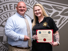 Sheriff Michael Adkinson holds an award standing next to Monica Webster, WCSO Lead Communications Officer