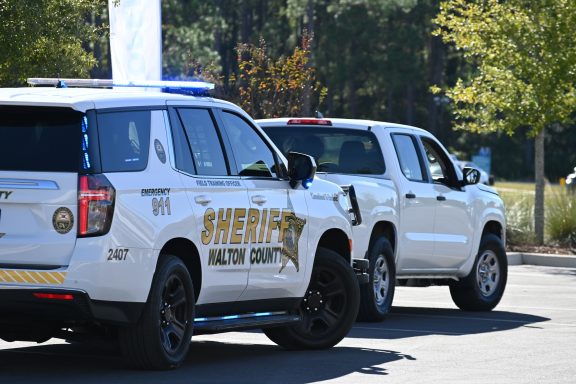 A Walton County Sheriff's Office marked patrol car pulled over behind a white Toyota truck. 