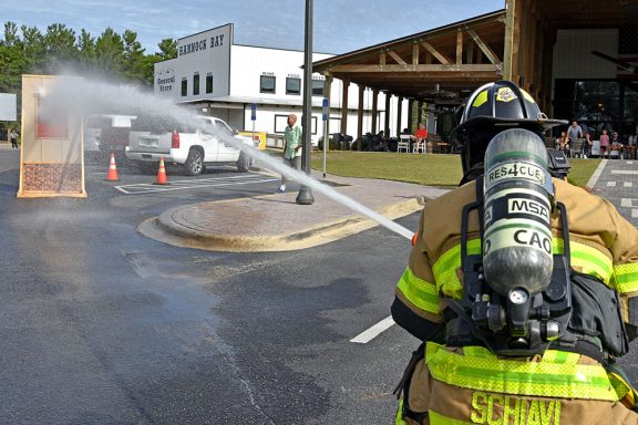 Firefighter spraying water at a wooden prop