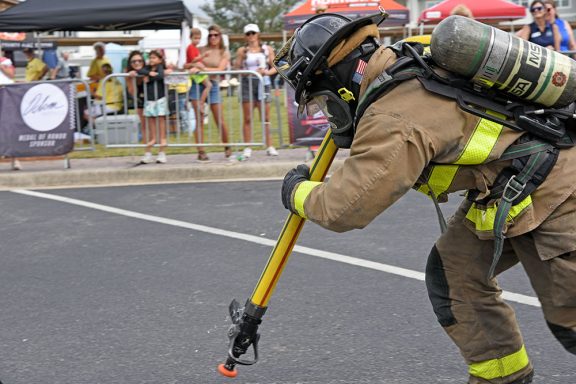 Side profile of firefighter pulling a full fire hose