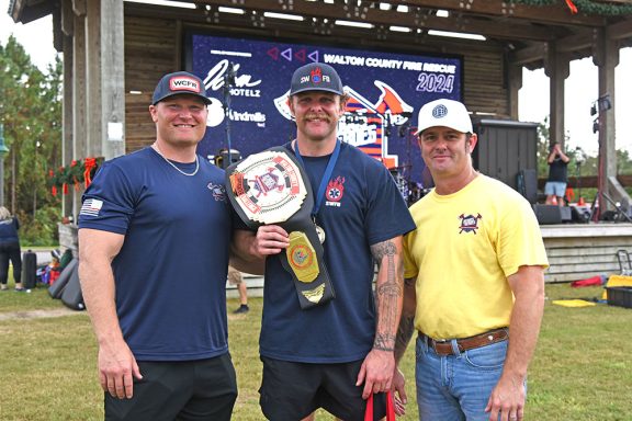 Firefighter holding a belt over his shoulder for winning the competition