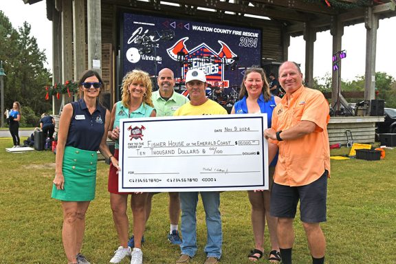 People holding a large check for $10,000