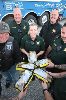 Four deputies and a motorcycle rider hold five LifeVacs in the shape of a star. 