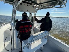 Two deputies looking out on Choctawhatchee Bay from a boat