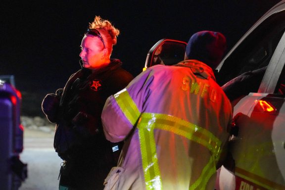 A deputy and firefighter talking in front of a truck