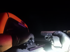 A gun held by a deputy with black gloves on.