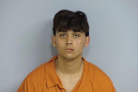 Hispanic male with shore black hair wearing an orange jumpsuit