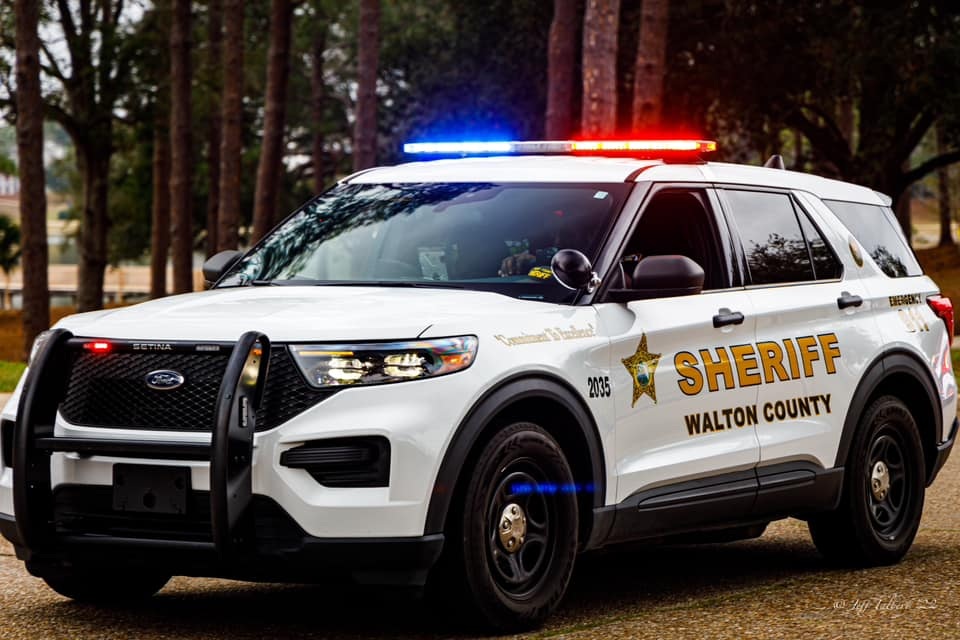 White Sheriff's Office SUV with blue and red light bar on top