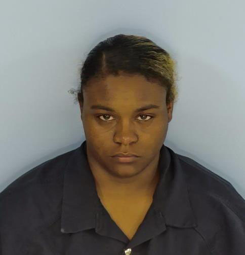 Female African American Woman with black hair pulled back wearing a dark gray shirt