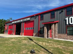 Dark gray and red metal fire station that says Choctaw Beach Fire Station