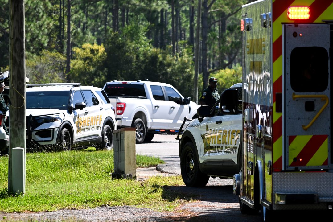Patrol cars parked sporadically near an ambulance