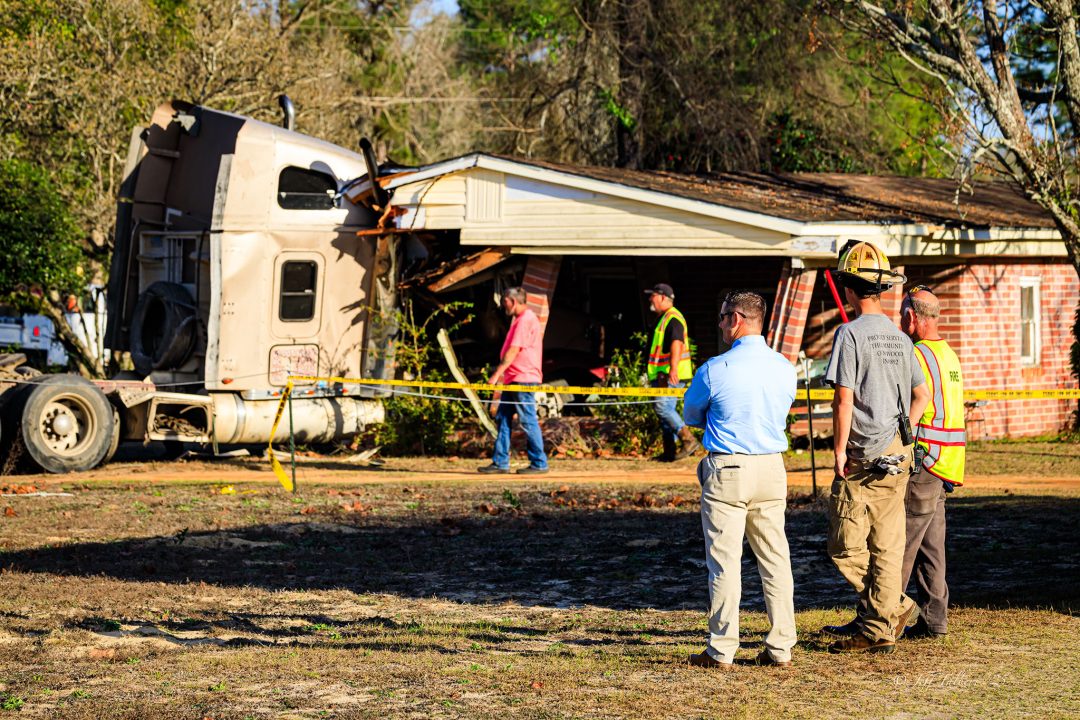 Fire chiefs standing in front of scene where a semi crashed into a home
