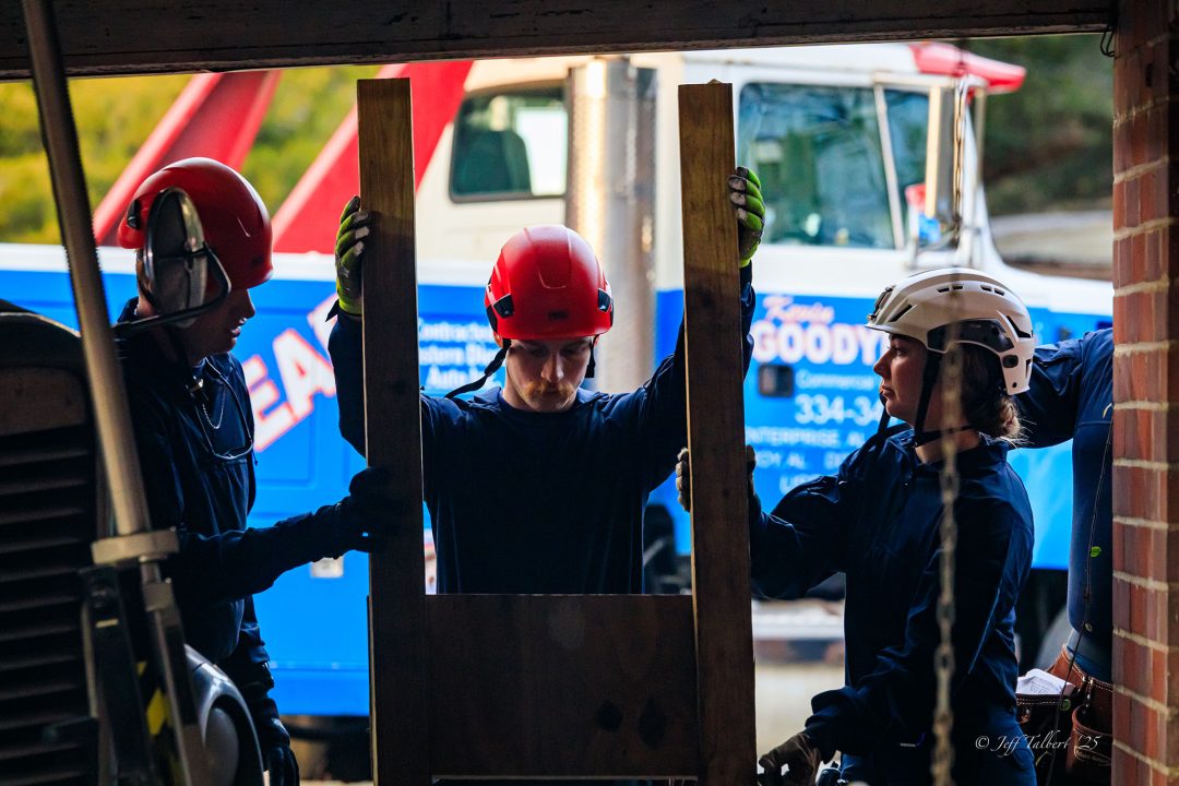Three firefighters putting up support beams
