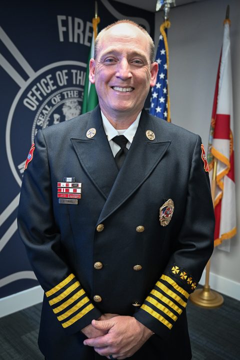 White male wearing a navy blue Class A fire rescue uniform